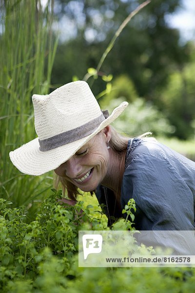 Smiling mature woman working in garden
