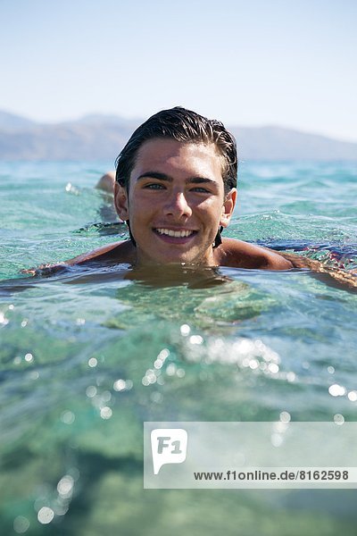 Smiling teenage boy bathing in sea