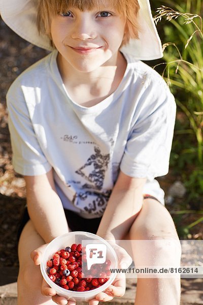 Junge - Person  halten  ungestüm  Erdbeere