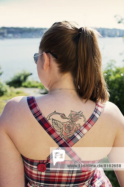 Young woman with tattoo on back