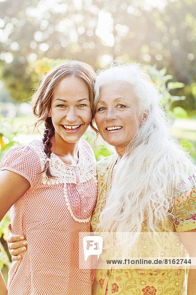 Portrait of adult daughter and mother in garden