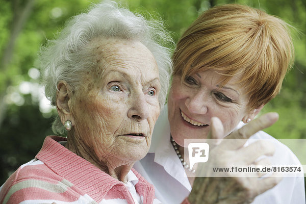 Deutschland Nordrhein-Westfalen Köln Seniorin und reife Frau im Park lächelnd
