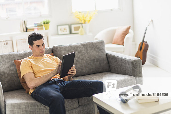 sitzend  benutzen  Mann  Couch  Tablet PC