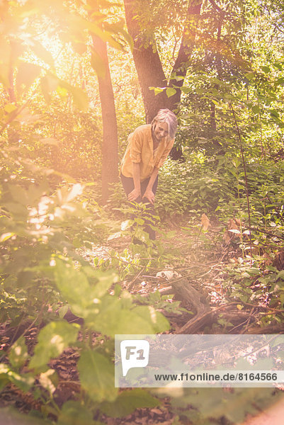 Senior woman hiking in sunny forest