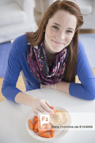 Portrait of teenage girl (14-15) with healthy snacks
