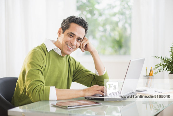 Portrait of man working on laptop at home