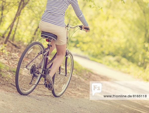 Mid adult woman riding bicycle  low section