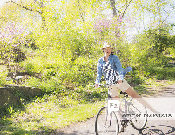 Mid adult woman riding bicycle
