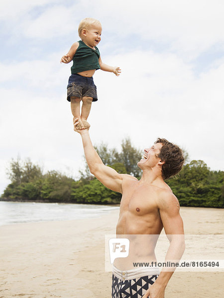 Father with son (6-11 months) on beach