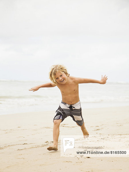 Boy (6-7) playing on beach