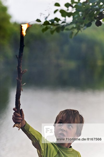 Junge - Person halten Flamme Holzstock Stock