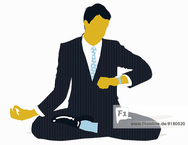 Businessman sitting in lotus position and checking the time on wristwatch