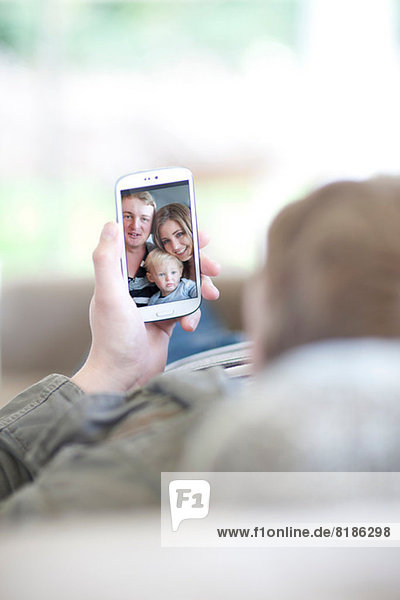 Man looking at family photo on cellphone