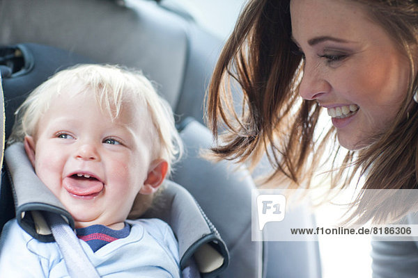 Mother with baby son in back seat of car