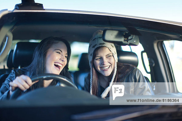 Two young women driving car