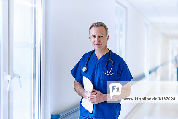Doctor standing in corridor holding medical records