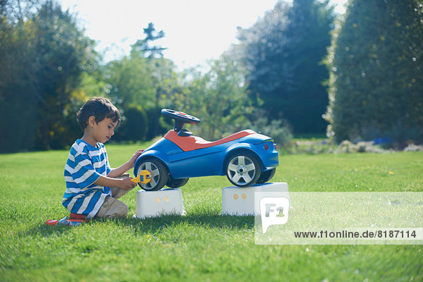 Boy pretending to fix toy car