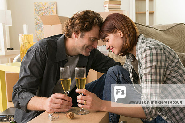 Couple sharing champagne break whilst moving