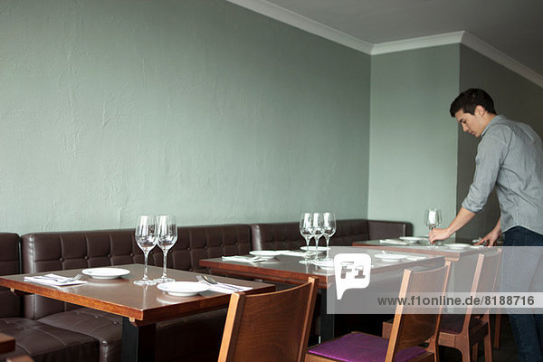 Waiter Setting Table In Restaurant