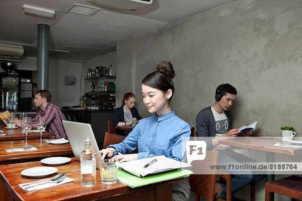 Junge Frau mit Laptop im Café