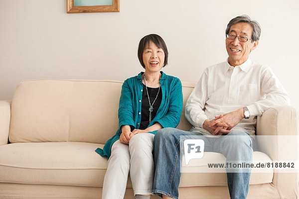 Senior couple sitting on sofa  portrait