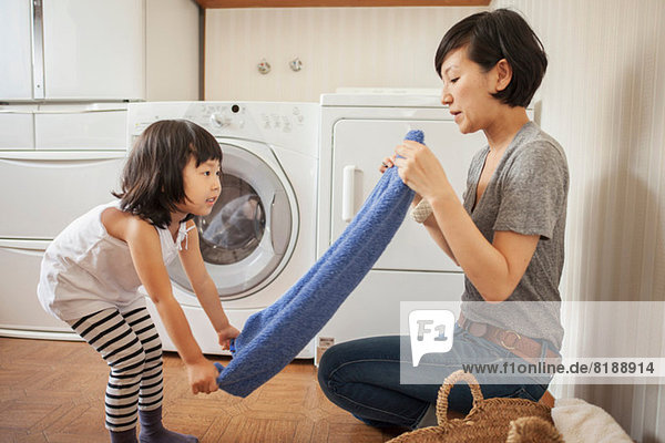 Mother and daughter folding towel