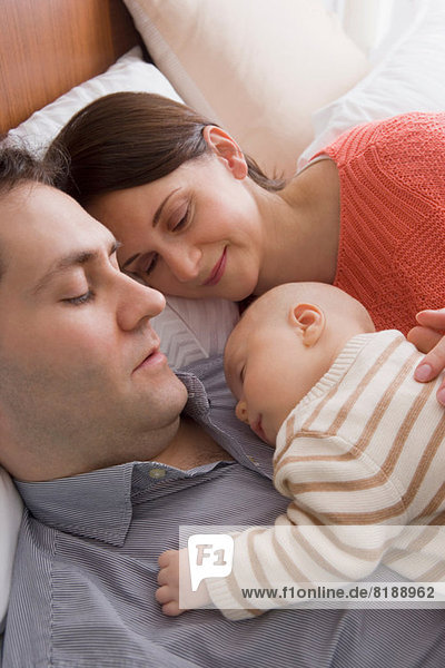 Parents resting together with baby boy