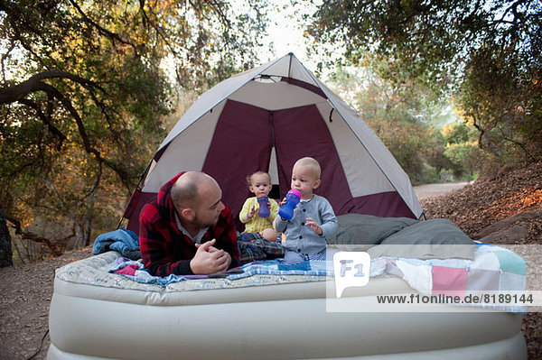 Kleinkind Zwillinge auf Campingmatratze mit Vater