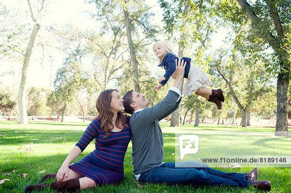 Junge Eltern im Park mit weiblichem Kleinkind