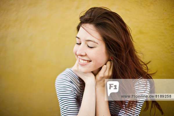 Candid portrait of young woman with eyes closed