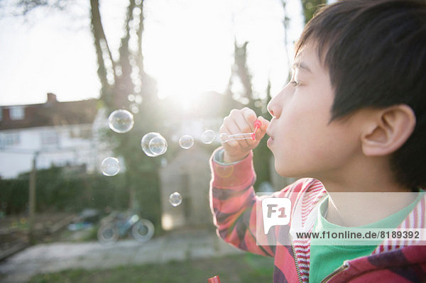 Boy blowing bubbles with wand  close up