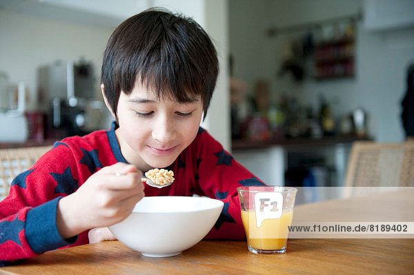 Boy eating breakfast cereal at table