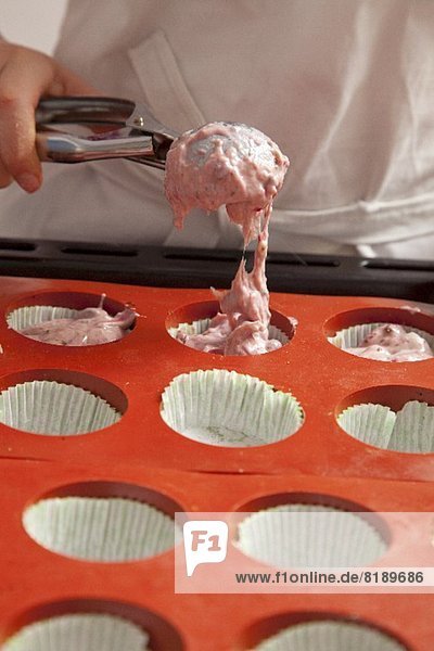 Muffinteig in die Backförmchen füllen
