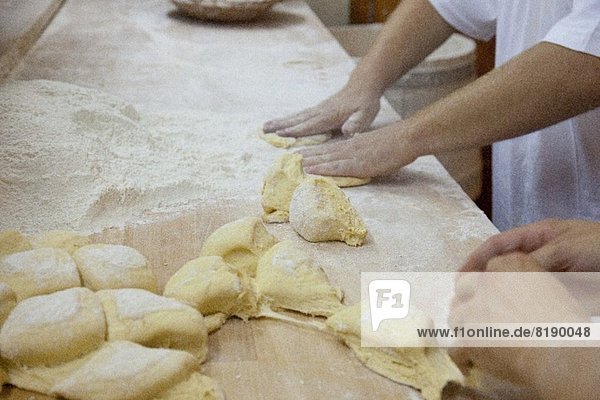 Bäcker formen Brötchen mit den Händen