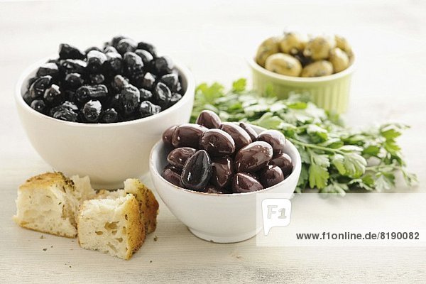 Kalamata olives in bowls  with bread and parsley