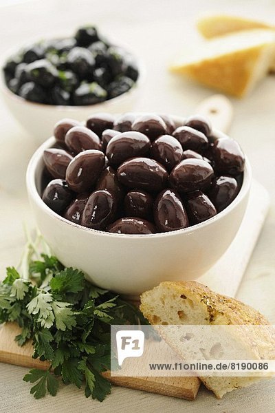 Kalamata olives in a bowl  with parsley and bread