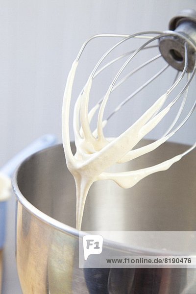 Rührbesen einer Küchenmaschine mit geschlagenem Eisweiss