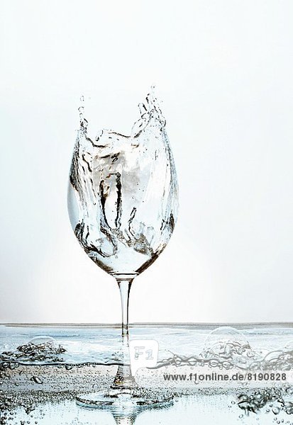Mit spritzendem Wasser gefülltes Stielglas