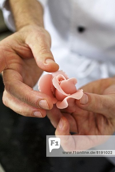 A confectioner shaping a marzipan rose