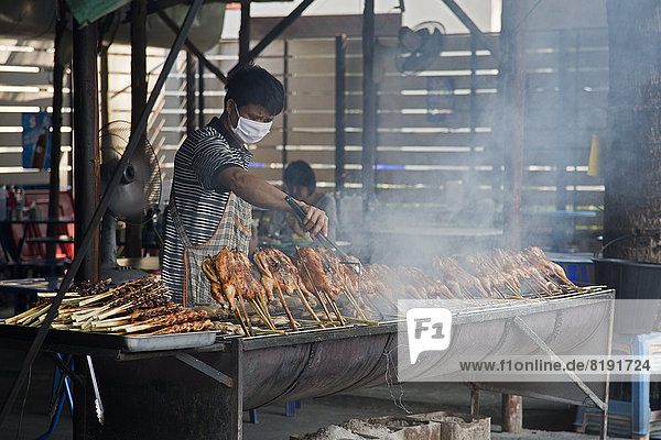 Vendor grilling chicken