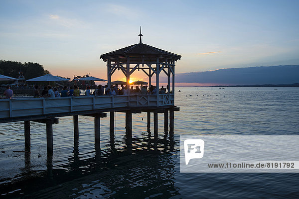 Pavilion with a bar on Lake Constance at sunset