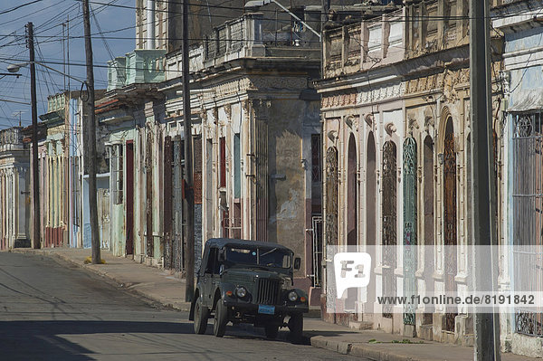 Straßenszene mit Kolonialbauten und einem Fahrzeug sowjetischer Produktion in Cienfuegos