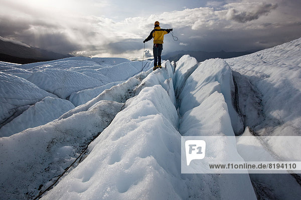 Bergsteiger steht am Matanuska-Gletscher und zieht an seinem Seil
