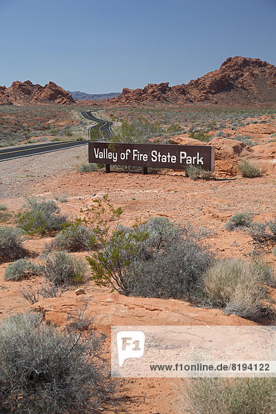 'Schild ''Valley of Fire State Park''  mit den charakteristischen roten Sandstein-Formationen'
