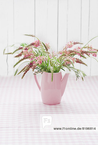 Strauß rosa Blumen in Dose auf Tisch,  Nahaufnahme