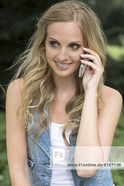 Young woman talking on mobile phone  smiling
