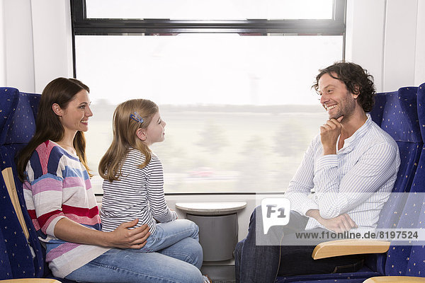 Germany  Brandenburg  Family traveling in train  smiling