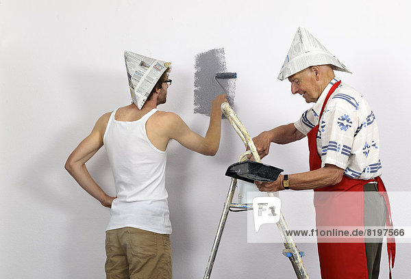 Germany  Grandfather and grandson painting wall