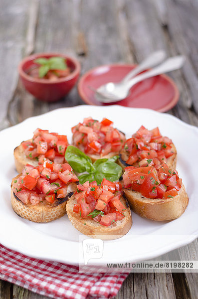 Bruschetta with tomatoe and basil on plate  close up