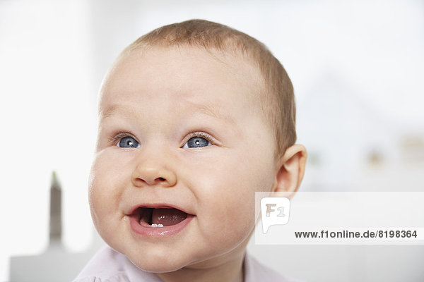 Deutschland  Nordrhein-Westfalen    Baby Mädchen schaut weg  lächelnd